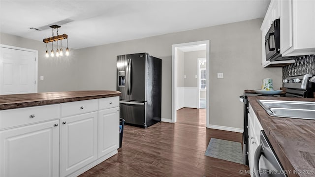 1412 Healdton Blvd, Ardmore, OK 73401 - kitchen with butcher block countertops, fridge with ice dispenser, dark wood finished floors, black microwave, and dishwasher