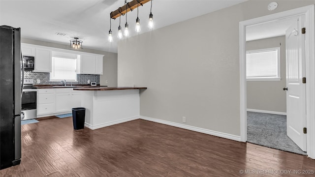 1412 Healdton Blvd, Ardmore, OK 73401 - kitchen featuring black microwave, dark countertops, stainless steel range with electric cooktop, freestanding refrigerator, and dark wood-style floors