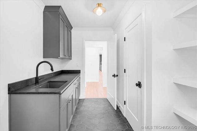 4155 S Birmingham Pl, Tulsa, OK 74105 - laundry area featuring a sink and dark tile patterned flooring