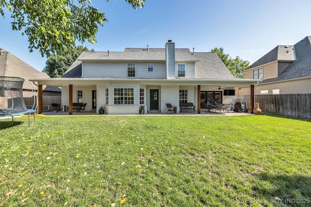 5414 E 109th Pl, Tulsa, OK 74137 - back of property with a trampoline, a patio area, a fenced backyard, a chimney, and ceiling fan