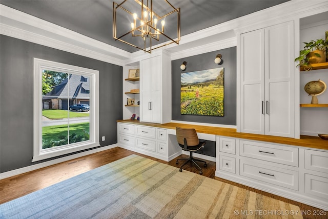 5414 E 109th Pl, Tulsa, OK 74137 - home office with built in desk, wood finished floors, a chandelier, and crown molding