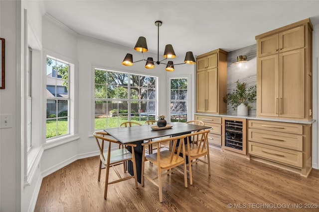 5414 E 109th Pl, Tulsa, OK 74137 - dining area featuring beverage cooler, a chandelier, light wood-style flooring, plenty of natural light, and crown molding