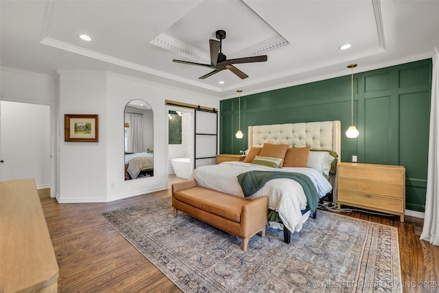 5414 E 109th Pl, Tulsa, OK 74137 - bedroom featuring a tray ceiling, a barn door, ornamental molding, wood finished floors, and recessed lighting