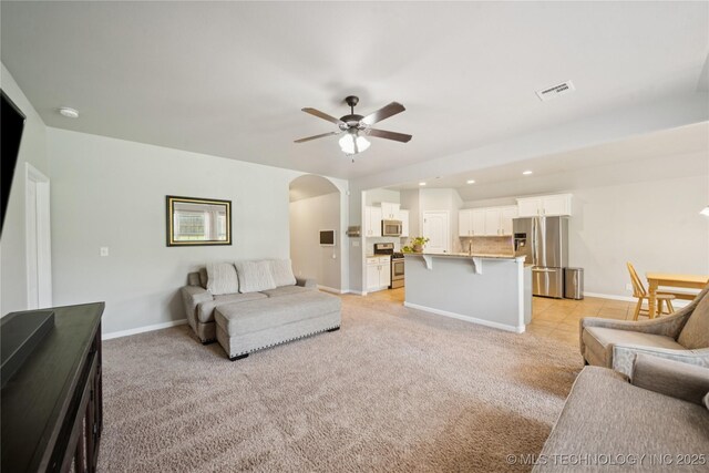 9246 N 143rd E Ave, Owasso, OK 74055 - living room featuring a ceiling fan, arched walkways, recessed lighting, and light colored carpet