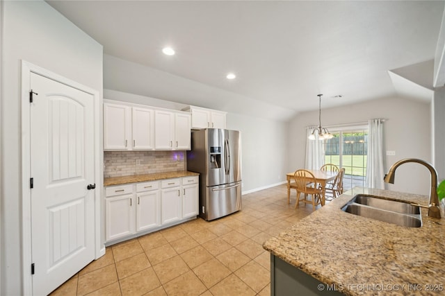 9246 N 143rd E Ave, Owasso, OK 74055 - kitchen with stainless steel fridge with ice dispenser, light tile patterned floors, vaulted ceiling, decorative backsplash, and white cabinets