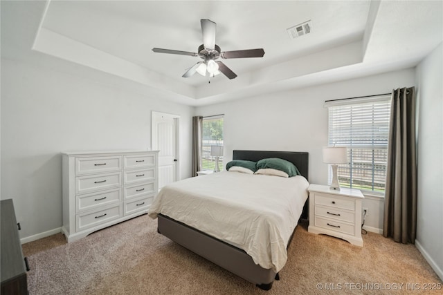 9246 N 143rd E Ave, Owasso, OK 74055 - bedroom with a tray ceiling, light carpet, and a ceiling fan