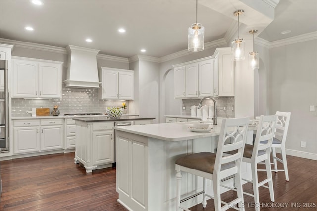 4620 E 108th Pl S, Tulsa, OK 74137 - kitchen with custom exhaust hood, tasteful backsplash, dark wood-type flooring, a center island, and a breakfast bar area
