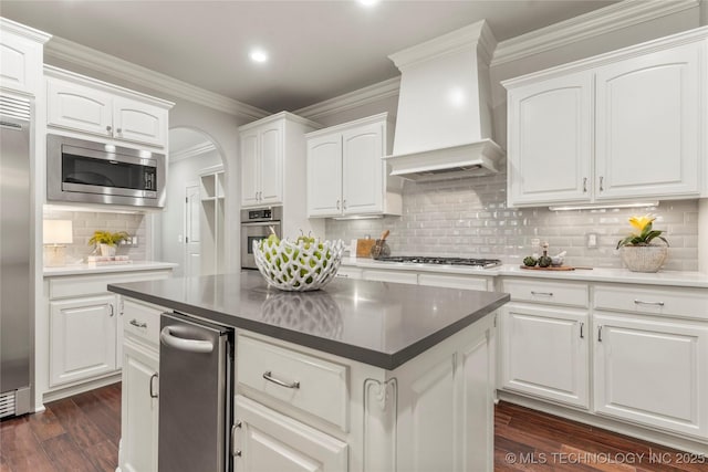 4620 E 108th Pl S, Tulsa, OK 74137 - kitchen with built in appliances, premium range hood, tasteful backsplash, dark wood-style flooring, and white cabinets