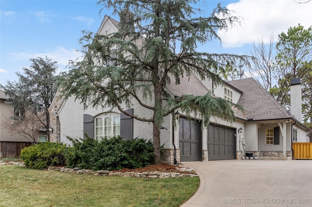 4620 E 108th Pl S, Tulsa, OK 74137 - view of front of house with stone siding, concrete driveway, an attached garage, a shingled roof, and a chimney