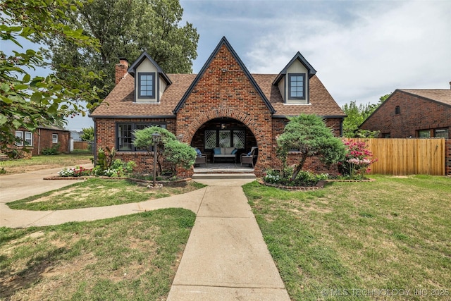 1743 S Florence Pl, Tulsa, OK 74104 - tudor home with a chimney, brick siding, a shingled roof, outdoor lounge area, and french doors