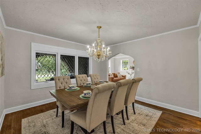 1743 S Florence Pl, Tulsa, OK 74104 - dining room with a textured ceiling, arched walkways, a chandelier, wood finished floors, and crown molding