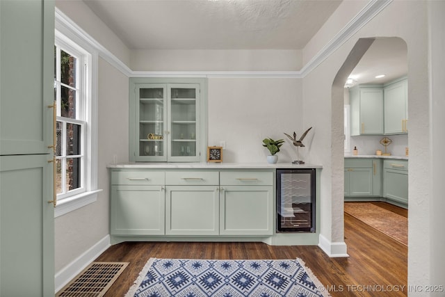 1743 S Florence Pl, Tulsa, OK 74104 - bar with wine cooler, arched walkways, dark wood finished floors, and healthy amount of natural light
