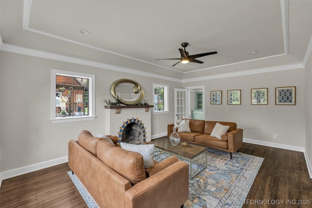 1743 S Florence Pl, Tulsa, OK 74104 - living room featuring a tray ceiling, ceiling fan, a brick fireplace, wood finished floors, and crown molding