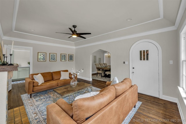 1743 S Florence Pl, Tulsa, OK 74104 - living room with arched walkways, a tray ceiling, dark wood finished floors, a ceiling fan, and ornamental molding