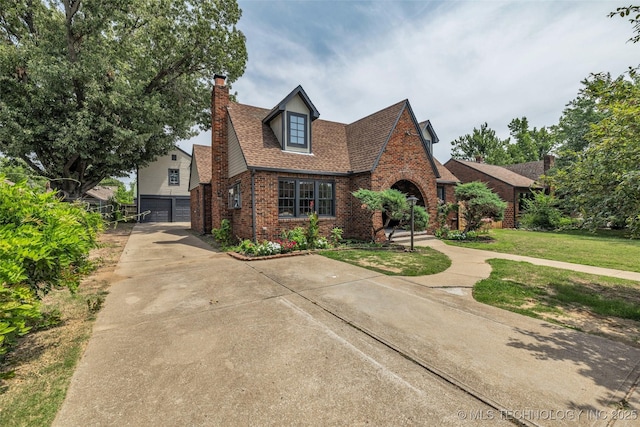 1743 S Florence Pl, Tulsa, OK 74104 - tudor-style house with brick siding, driveway, a chimney, a garage, and a front yard