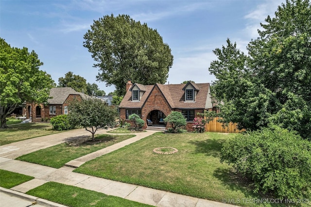 1743 S Florence Pl, Tulsa, OK 74104 - view of front of house with a chimney, a front lawn, brick siding, and concrete driveway