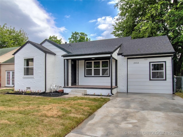 2532 E 4th St, Tulsa, OK 74104 - view of front facade with brick siding, covered porch, a shingled roof, and a front yard