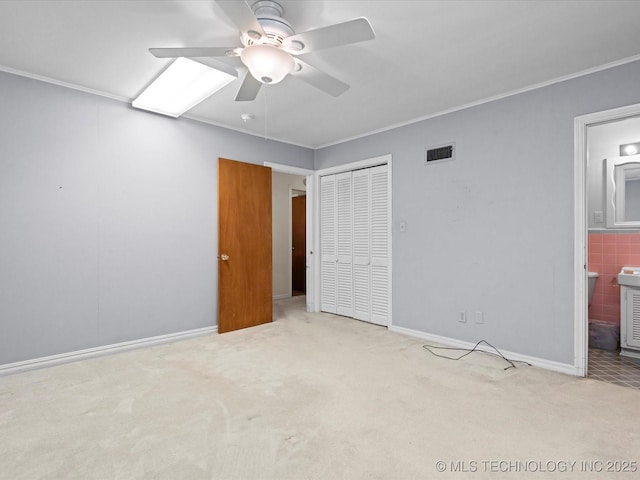 320 E 7th St, Pawhuska, OK 74056 - unfurnished bedroom featuring carpet floors, a closet, ornamental molding, a ceiling fan, and ensuite bath