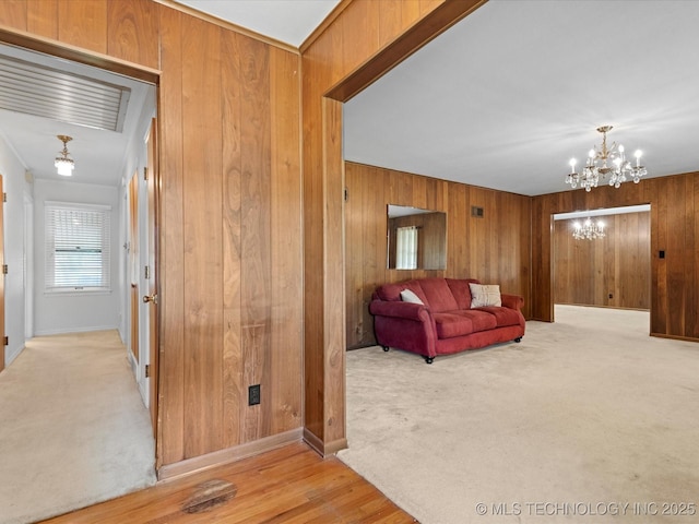 320 E 7th St, Pawhuska, OK 74056 - living room with wooden walls, a chandelier, and light colored carpet