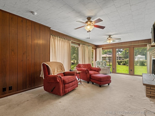 320 E 7th St, Pawhuska, OK 74056 - living area with carpet, healthy amount of natural light, a ceiling fan, and wooden walls