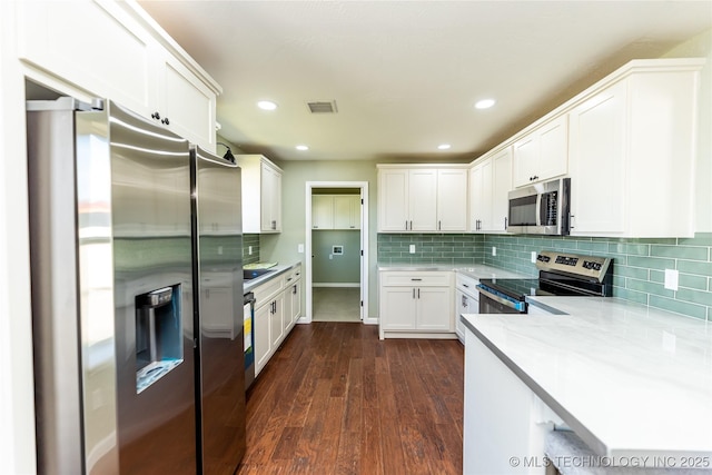 410 Denver St, Pawnee, OK 74058 - kitchen featuring appliances with stainless steel finishes, white cabinets, dark wood-type flooring, backsplash, and recessed lighting
