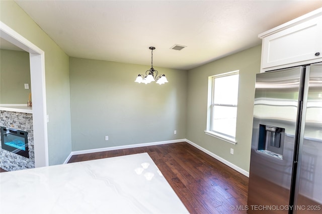 410 Denver St, Pawnee, OK 74058 - unfurnished dining area with a chandelier, dark wood-style floors, and a stone fireplace