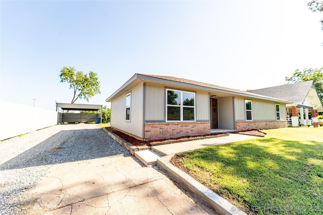 410 Denver St, Pawnee, OK 74058 - ranch-style house with brick siding, gravel driveway, a front lawn, and a carport