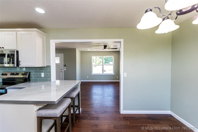 410 Denver St, Pawnee, OK 74058 - kitchen featuring stainless steel appliances, white cabinets, tasteful backsplash, dark wood-style flooring, and recessed lighting