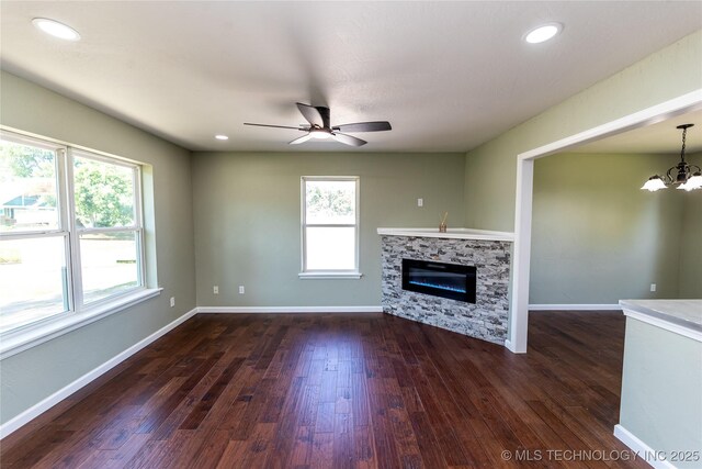 410 Denver St, Pawnee, OK 74058 - unfurnished living room featuring dark wood finished floors, ceiling fan, a glass covered fireplace, a chandelier, and recessed lighting