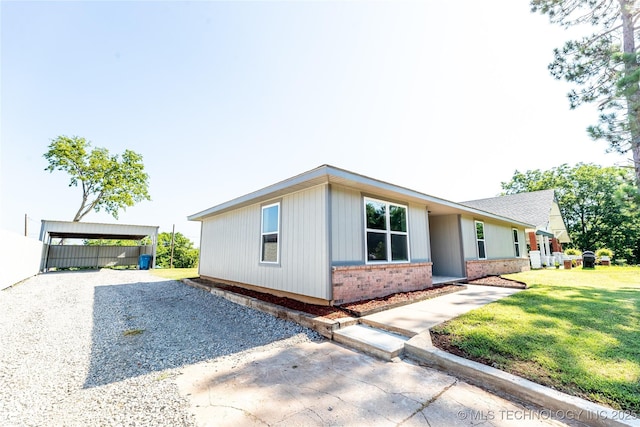 410 Denver St, Pawnee, OK 74058 - view of front of house featuring brick siding, driveway, a front yard, and a carport