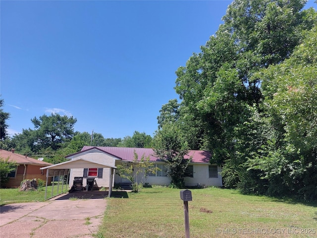 1713 E 10th St, Okmulgee, OK 74447 - view of front of home with concrete driveway, a front yard, and a metal roof