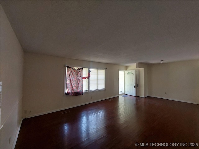 1713 E 10th St, Okmulgee, OK 74447 - spare room with dark wood-style floors and baseboards