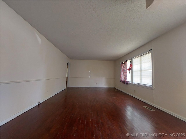 1713 E 10th St, Okmulgee, OK 74447 - spare room with wood finished floors and a textured ceiling