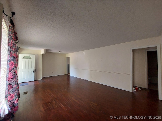 1713 E 10th St, Okmulgee, OK 74447 - empty room featuring wood finished floors and a textured ceiling