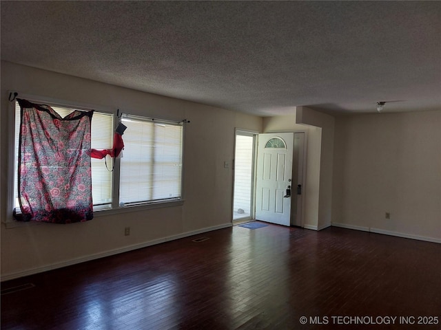 1713 E 10th St, Okmulgee, OK 74447 - foyer featuring hardwood / wood-style flooring and a textured ceiling