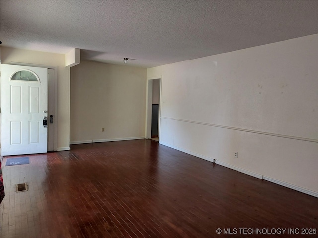 1713 E 10th St, Okmulgee, OK 74447 - unfurnished room featuring wood-type flooring and a textured ceiling