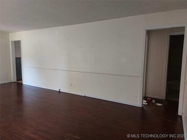 1713 E 10th St, Okmulgee, OK 74447 - empty room featuring wood finished floors and baseboards