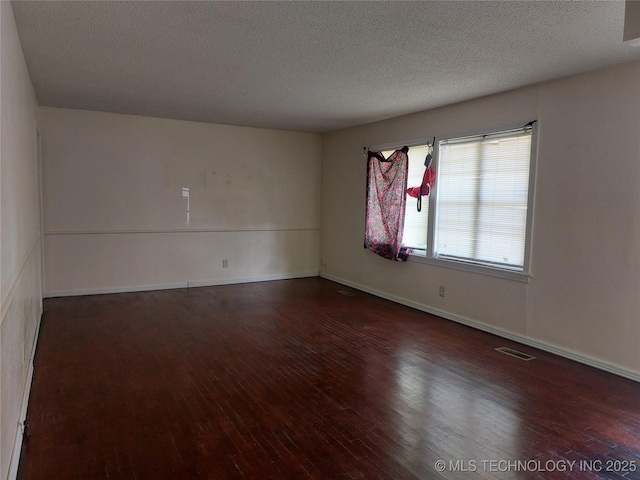 1713 E 10th St, Okmulgee, OK 74447 - unfurnished room featuring hardwood / wood-style flooring and a textured ceiling