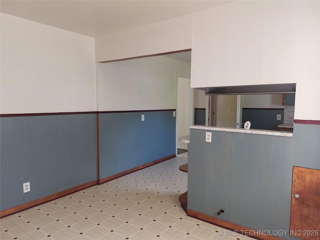 1713 E 10th St, Okmulgee, OK 74447 - empty room featuring a wainscoted wall and tile patterned floors