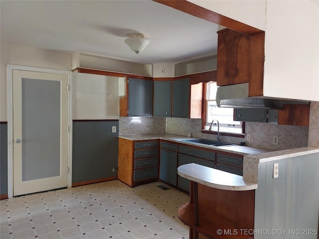 1713 E 10th St, Okmulgee, OK 74447 - kitchen with light countertops, light flooring, and decorative backsplash