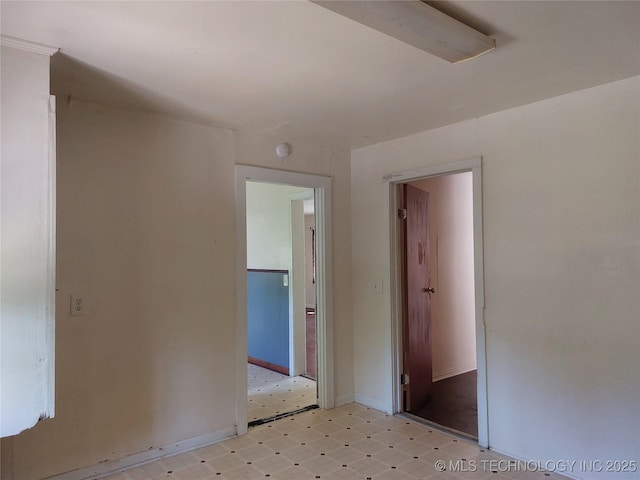 1713 E 10th St, Okmulgee, OK 74447 - unfurnished bedroom with light flooring and baseboards