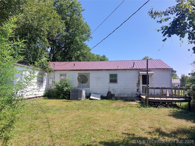1713 E 10th St, Okmulgee, OK 74447 - back of house with a wooden deck, a yard, and a metal roof