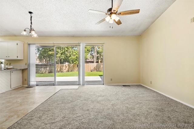 14127 E 24th Pl, Tulsa, OK 74134 - unfurnished living room featuring a textured ceiling, healthy amount of natural light, a ceiling fan, a chandelier, and light tile patterned flooring
