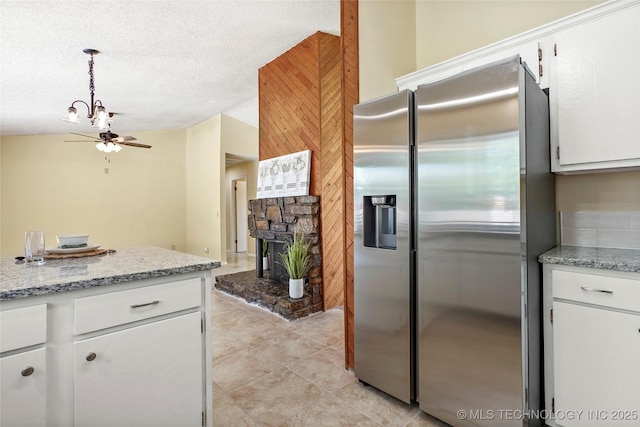 14127 E 24th Pl, Tulsa, OK 74134 - kitchen with stainless steel refrigerator with ice dispenser, white cabinetry, a fireplace with raised hearth, a ceiling fan, and a textured ceiling