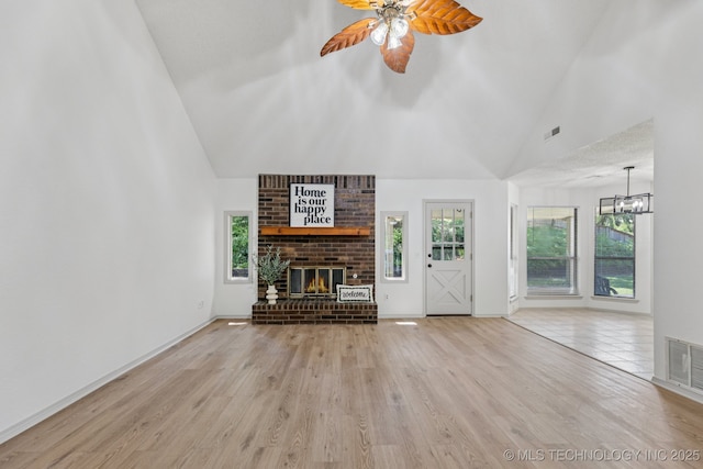 2244 W 45th St, Tulsa, OK 74107 - unfurnished living room featuring a brick fireplace, high vaulted ceiling, healthy amount of natural light, ceiling fan, and wood finished floors