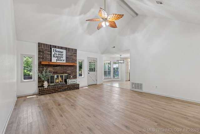 2244 W 45th St, Tulsa, OK 74107 - unfurnished living room with a brick fireplace, wood finished floors, a ceiling fan, beam ceiling, and high vaulted ceiling