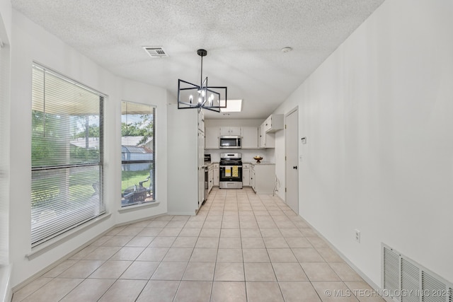 2244 W 45th St, Tulsa, OK 74107 - kitchen featuring stainless steel appliances, a chandelier, light countertops, light tile patterned floors, and decorative light fixtures