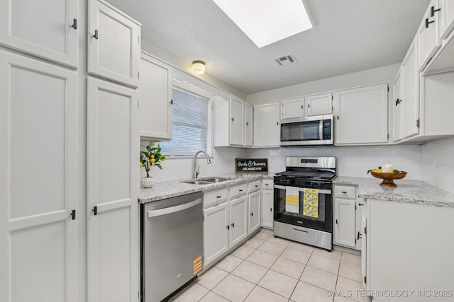 2244 W 45th St, Tulsa, OK 74107 - kitchen with stainless steel appliances, decorative backsplash, light tile patterned floors, light stone countertops, and a textured ceiling