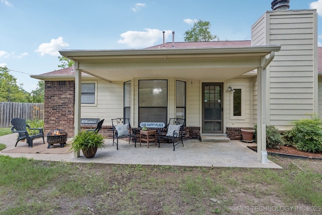 2244 W 45th St, Tulsa, OK 74107 - back of house featuring a fire pit, a chimney, a patio, roof with shingles, and brick siding