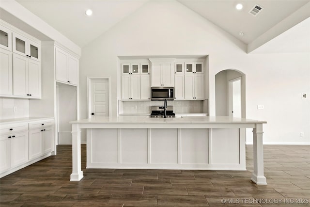2916 S 8th St, Broken Arrow, OK 74012 - kitchen with appliances with stainless steel finishes, arched walkways, white cabinetry, high vaulted ceiling, and recessed lighting